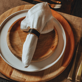 Pratos de bambu natural com guardanapo de pano branco e anél porta guardanapo preto